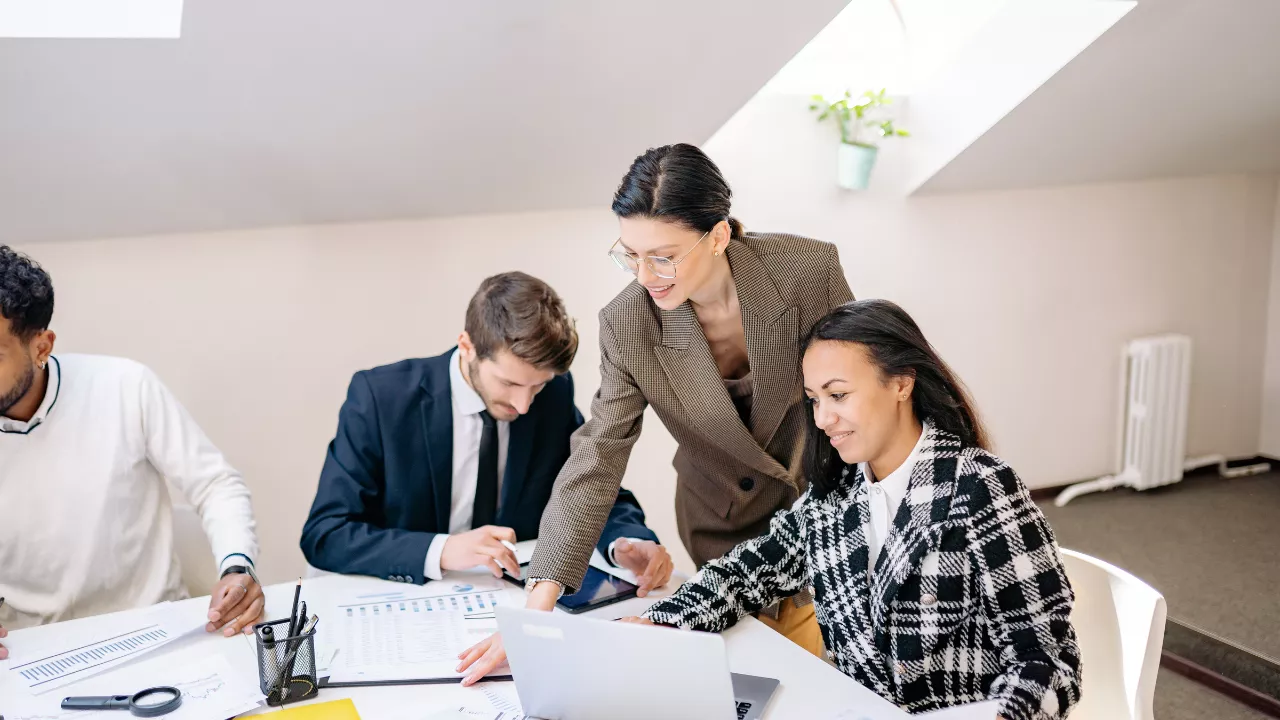 Diverse professional team collaborating in a modern office meeting room discussing business strategy and software decisions