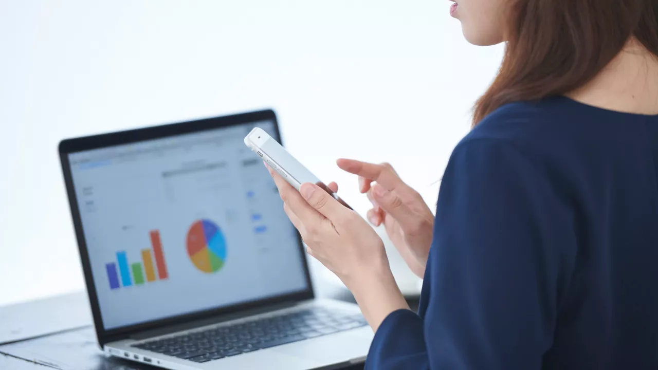 Modern laptop displaying a clean SaaS analytics dashboard with charts and data visualizations in a professional workspace