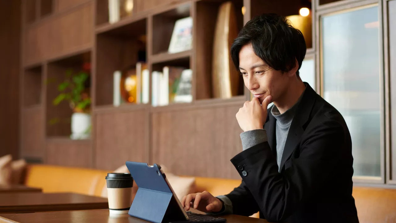 Thoughtful entrepreneur or founder working on laptop in a bright modern workspace